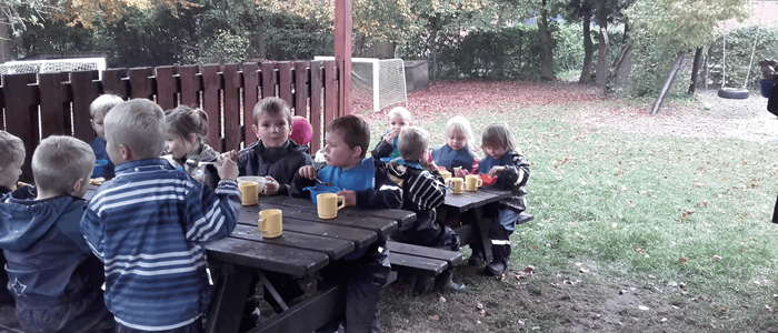 børn sidder sammen og spiser ved bord